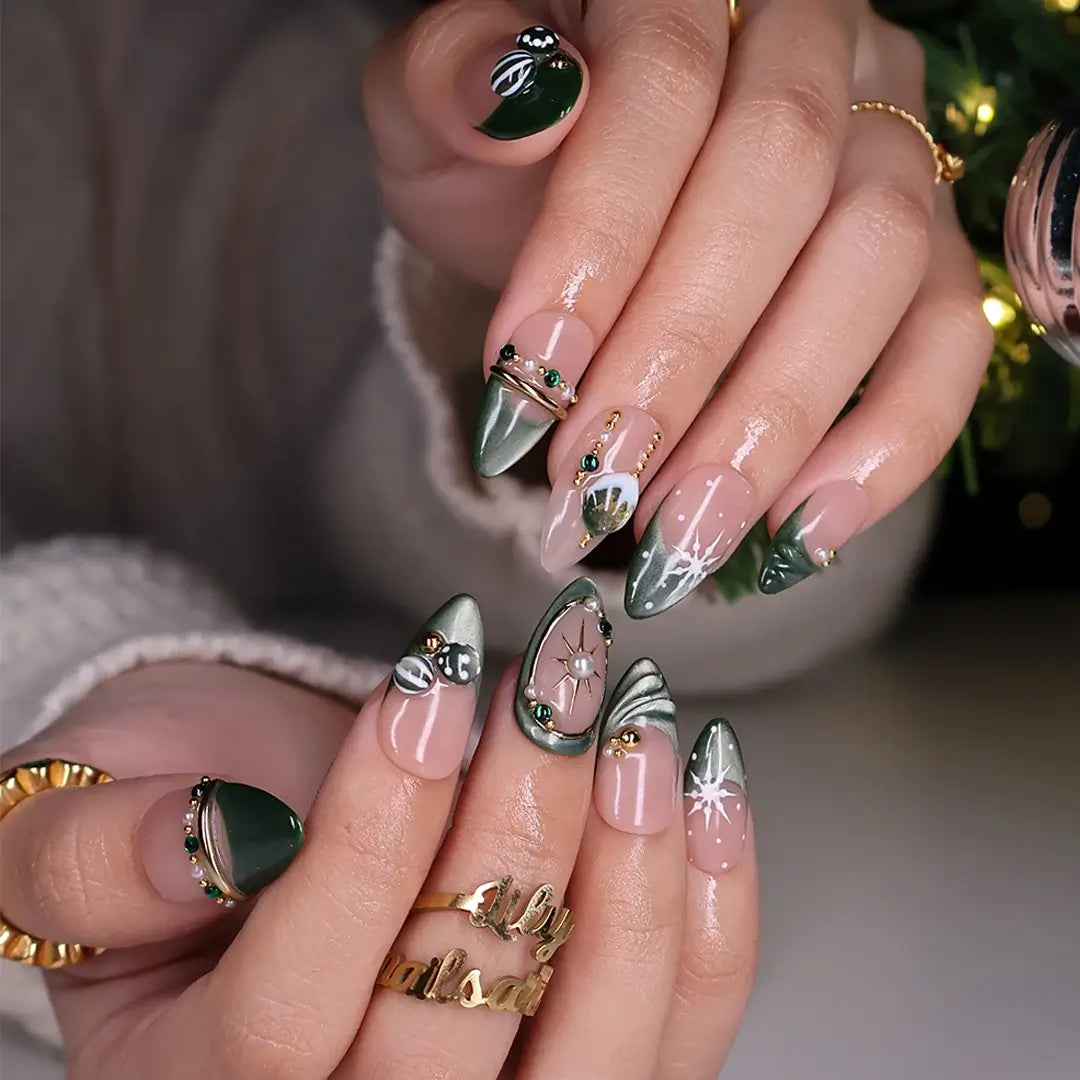 Emerald Eve handmade Christmas press-on nails — medium almond set in nude and sage-green cat-eye with 3D Christmas ornament baubles, gold starbursts, pearls, emerald gemstones and delicate snowflake accents.