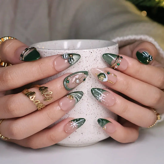 Emerald Eve handmade Christmas press-on nails — medium almond set in nude and sage-green cat-eye with 3D Christmas ornament baubles, gold starbursts, pearls, emerald gemstones and delicate snowflake accents.