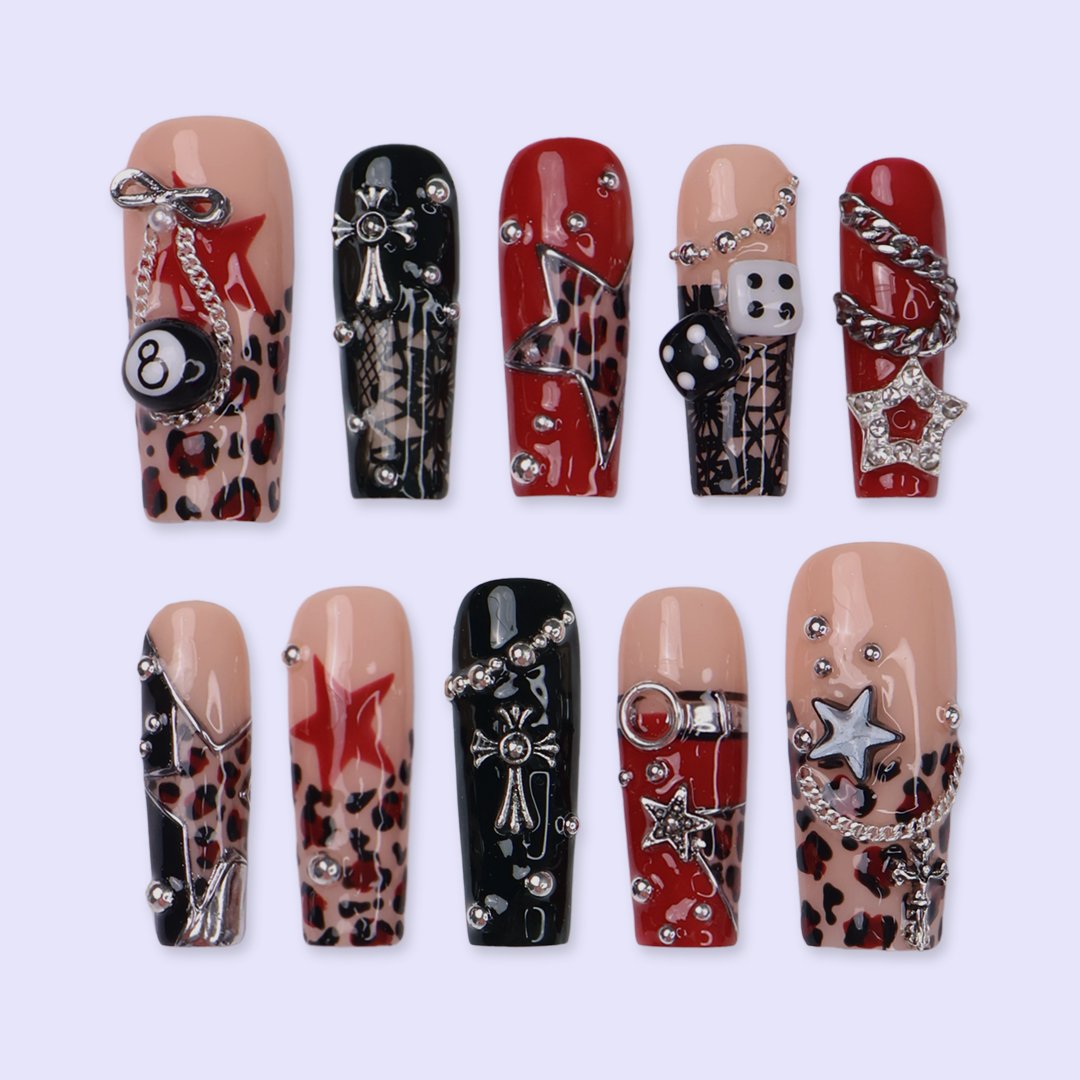 Lucky Riot handmade designer press-on nails — long square set in glossy red, black and nude with leopard print, stars, silver chains, eight ball, dice, metallic charms and rhinestone accents.