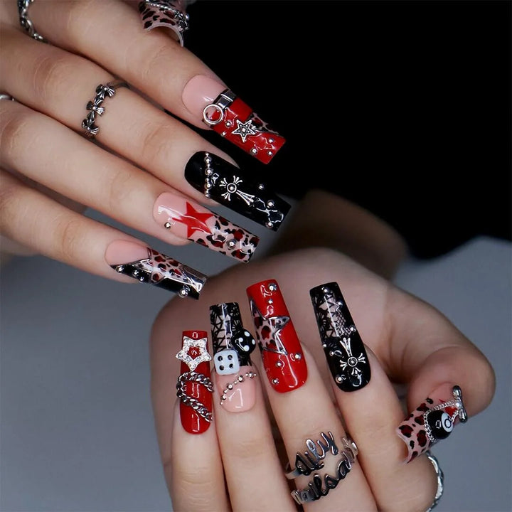 Lucky Riot handmade designer press-on nails — long square set in glossy red, black and nude with leopard print, stars, silver chains, eight ball, dice, metallic charms and rhinestone accents.