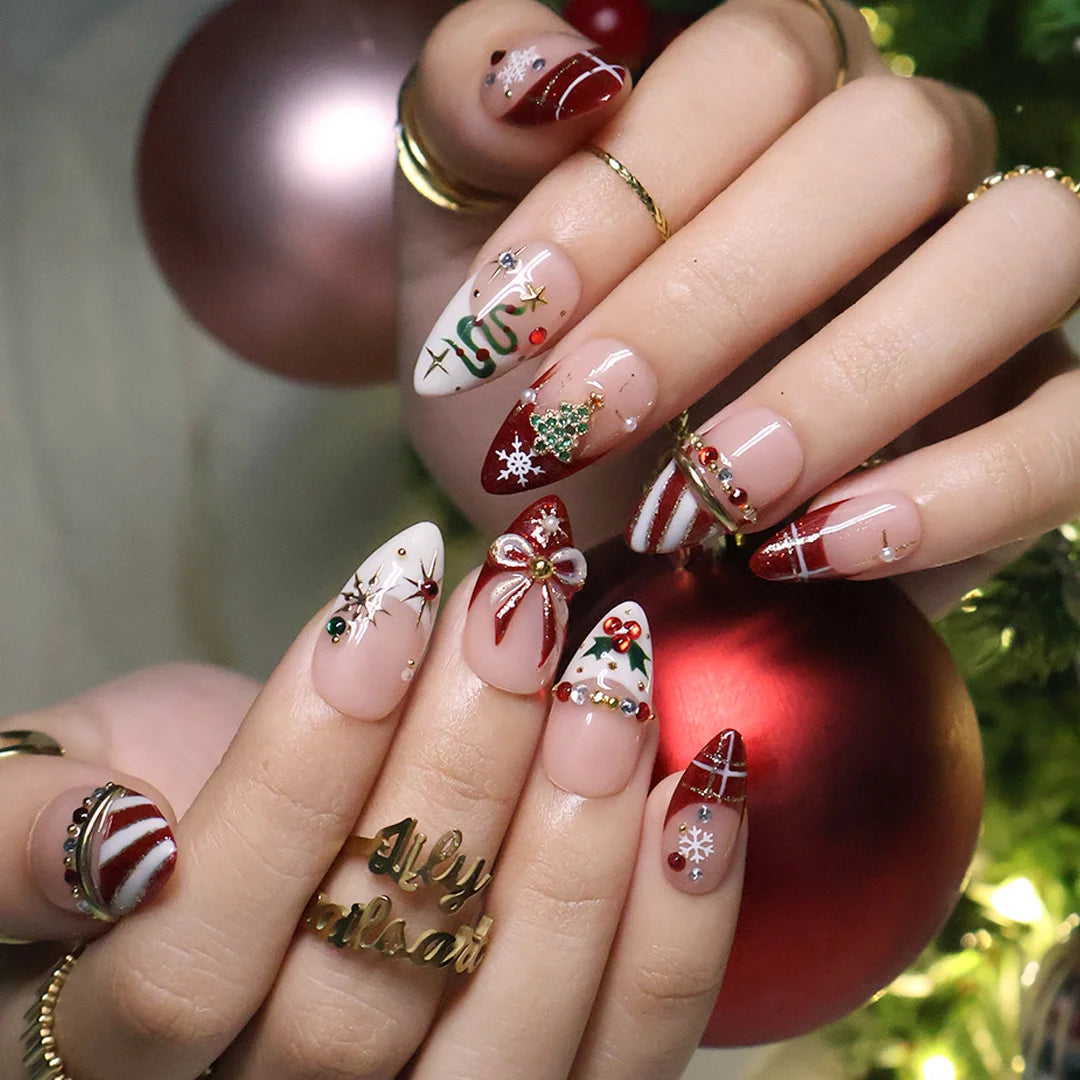 Jubilee handmade Christmas press-on nails — medium almond set in nude, red and cream with a glitter Christmas tree, snowflakes, red plaid, gold bow, holly berries, candy-cane stripes and gold star accents.