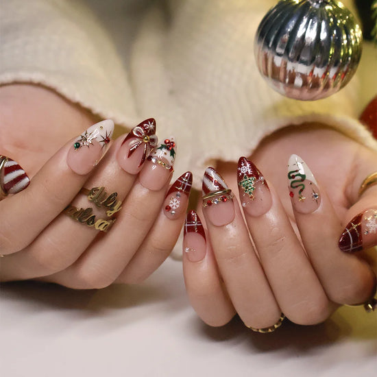 Jubilee handmade Christmas press-on nails — medium almond set in nude, red and cream with a glitter Christmas tree, snowflakes, red plaid, gold bow, holly berries, candy-cane stripes and gold star accents.