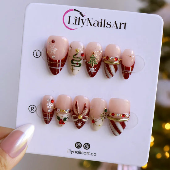 Jubilee handmade Christmas press-on nails — medium almond set in nude, red and cream with a glitter Christmas tree, snowflakes, red plaid, gold bow, holly berries, candy-cane stripes and gold star accents.