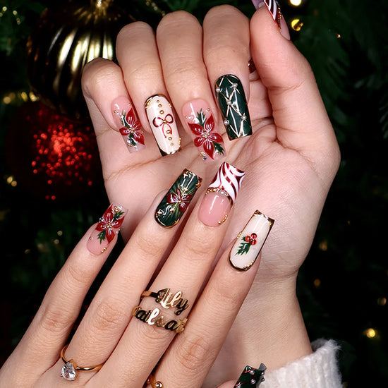 Yulamar handmade Christmas press-on nails — medium square set in nude, deep green and cream with 3D red poinsettias, red and gold bows, holly berries, candy-cane swirls, gold lattice details and pearl accents.