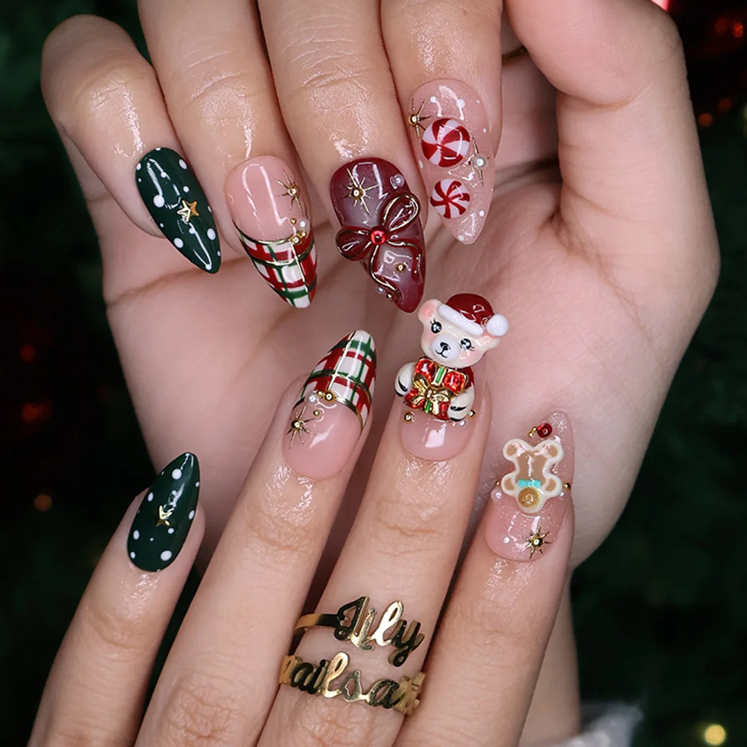 Gingerbread handmade Christmas press-on nails — medium almond set in nude, red and green with a 3D Santa-hat teddy bear, gingerbread man, peppermint candies, red and green plaid, snowflakes, gold stars and bow accents.