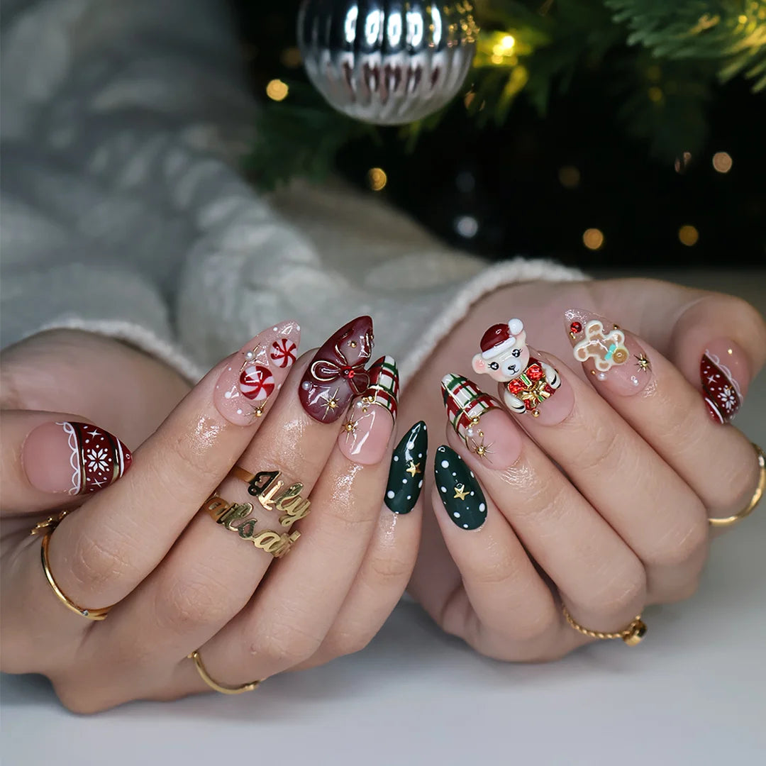 Gingerbread handmade Christmas press-on nails — medium almond set in nude, red and green with a 3D Santa-hat teddy bear, gingerbread man, peppermint candies, red and green plaid, snowflakes, gold stars and bow accents.