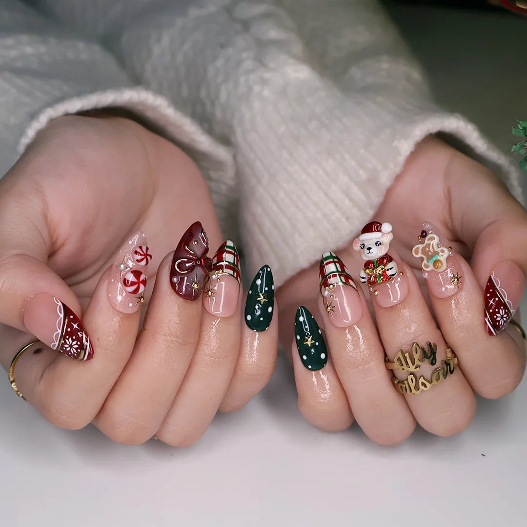 Gingerbread handmade Christmas press-on nails — medium almond set in nude, red and green with a 3D Santa-hat teddy bear, gingerbread man, peppermint candies, red and green plaid, snowflakes, gold stars and bow accents.