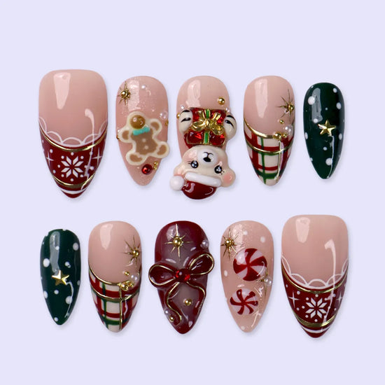 Gingerbread handmade Christmas press-on nails — medium almond set in nude, red and green with a 3D Santa-hat teddy bear, gingerbread man, peppermint candies, red and green plaid, snowflakes, gold stars and bow accents.