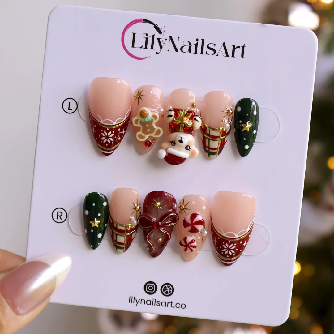 Gingerbread handmade Christmas press-on nails — medium almond set in nude, red and green with a 3D Santa-hat teddy bear, gingerbread man, peppermint candies, red and green plaid, snowflakes, gold stars and bow accents.