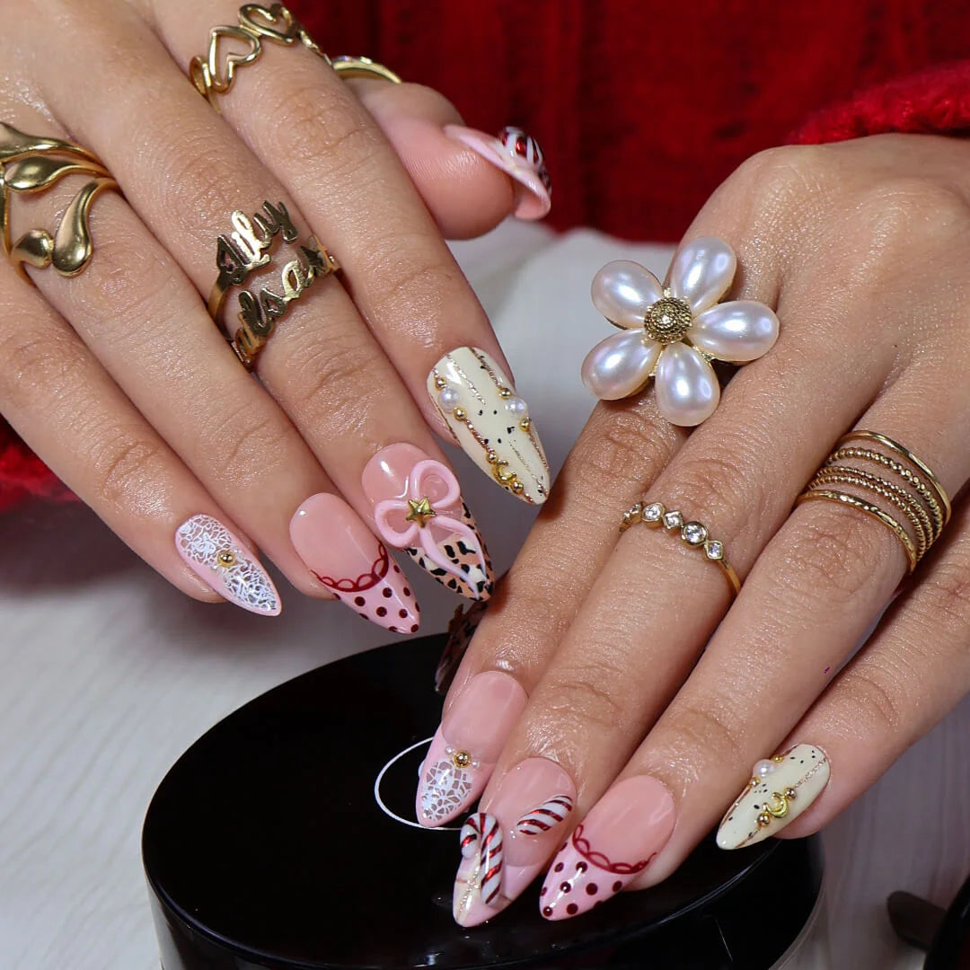 3D pink leopard print press on nails with red candy cane, gold bow, and peppermint swirl accents — handmade Christmas 2025 nails, festive fake nails, holiday nail art