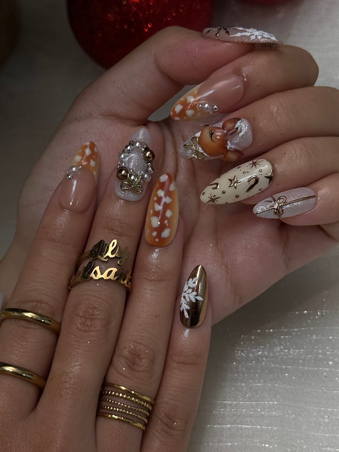 3D holiday press on nails in nude, caramel, and white with reindeer art, candy cane swirls, Christmas tree charms, metallic gold details — luxury handmade Christmas nails, reusable false nails, festive nail art — perfect for winter parties, holiday gifts, or cozy glam nights.