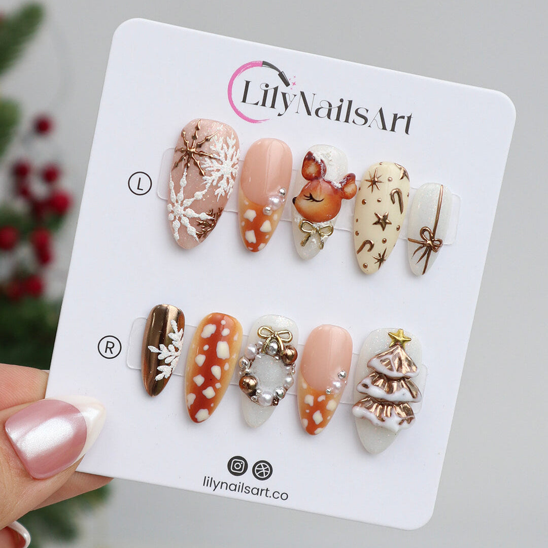 3D holiday press on nails in nude, caramel, and white with reindeer art, candy cane swirls, Christmas tree charms, metallic gold details — luxury handmade Christmas nails, reusable false nails, festive nail art — perfect for winter parties, holiday gifts, or cozy glam nights.