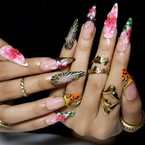 hand model wearing Green & pink handmade summer press-on nails — maximalist long almond set with tiger and zebra print, 3D pink lilies and gold beading
