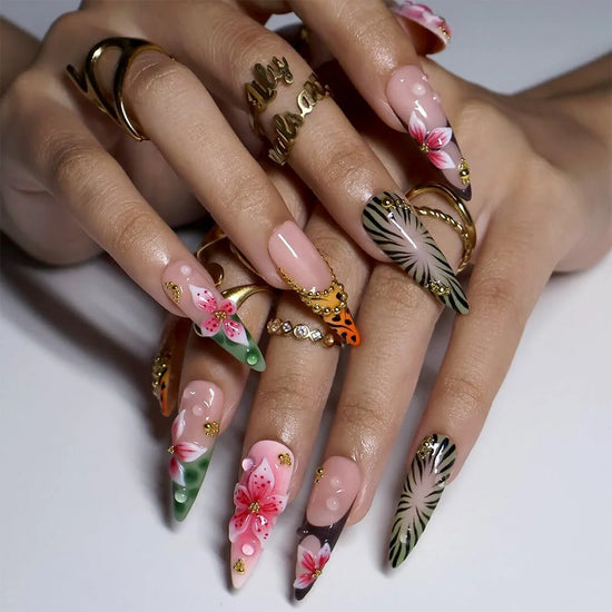 hand model wearing Green & pink handmade summer press-on nails — maximalist long almond set with tiger and zebra print, 3D pink lilies and gold beading
