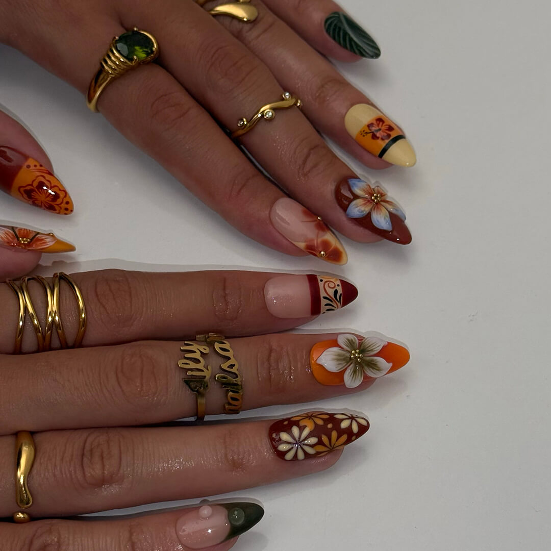 Fall inspired press-on nails with hibiscus flowers, tropical leaf accents, and gradients of red, orange, and golden tones — luxury handmade medium almond nails inspired by Tahitian sunsets and glowing embers — perfect for fall look, holiday 