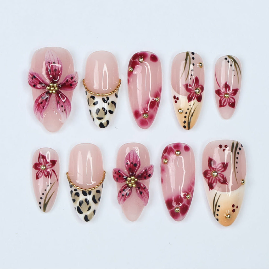 Handmade spring press-on nails featuring delicate 3D sakura flowers, leopard print French tips, and gold accents. Designed in a soft pink color palette with a glossy finish, perfect for floral nail lovers, holiday nails, vacation-ready nails, and birthday nail sets.