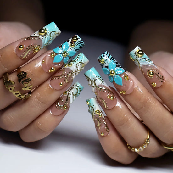 hand model wearing Vermentino handmade press-on nails — maximalist long square set in Tiffany blue with 3D turquoise lilies, gold swirls and leopard print
