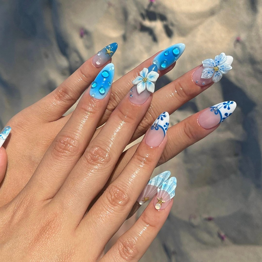 3D blue press on nails with ocean waves, starfish, seashells, and floral accents — luxury handmade summer nails for beach days and vacations.