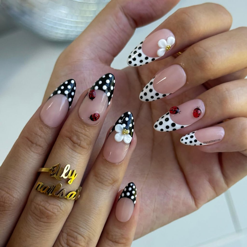 Hand with polka dot and floral nail designs on a neutral background