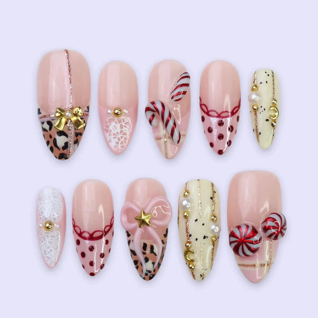 3D pink leopard print press on nails with red candy cane, gold bow, and peppermint swirl accents — handmade Christmas 2025 nails, festive fake nails, holiday nail art