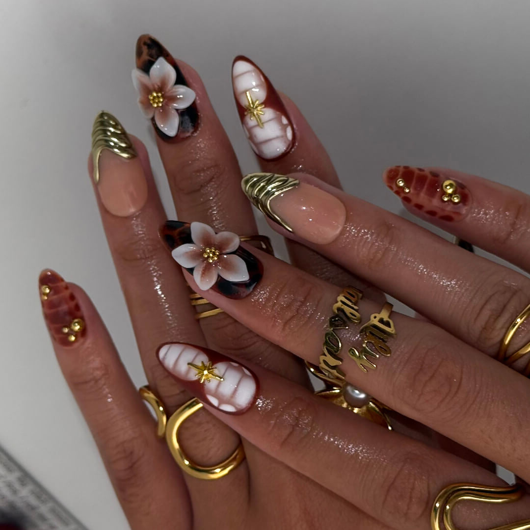 Luxury press-on nails with tortoiseshell patterns, 3D florals, and gold metallic accents on warm amber and nude bases — handmade medium almond nails — perfect for elegant everyday wear, chic autumn looks, or timeless luxury nail art.