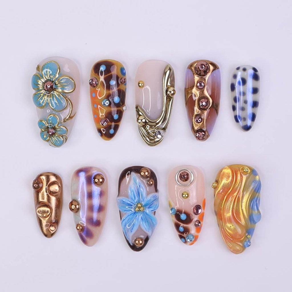 Metallic blue press on nails with sculpted floral accents and bronze chrome — custom almond shape for summer or Y2K looks
