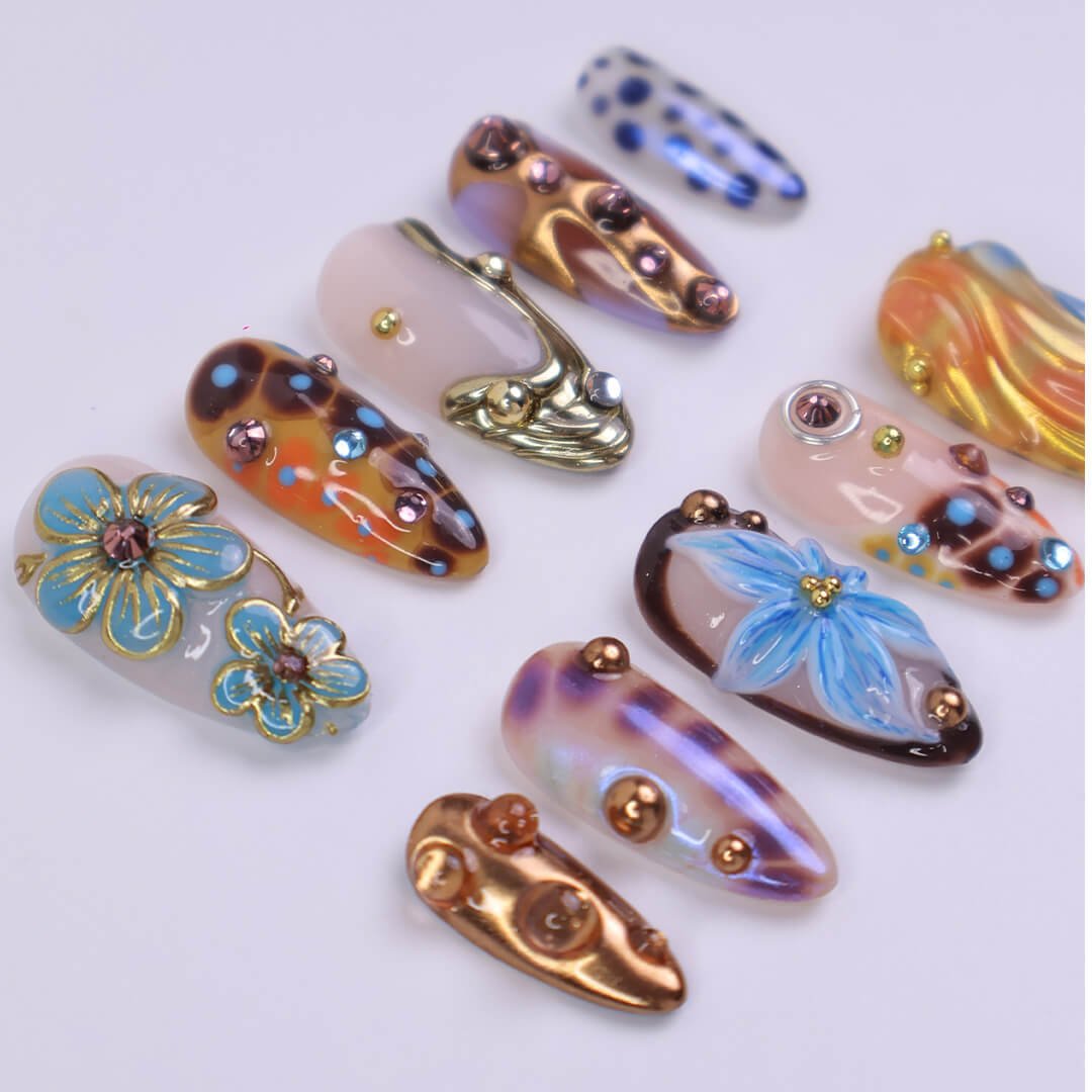Metallic blue press on nails with sculpted floral accents and bronze chrome — custom almond shape for summer or Y2K looks
