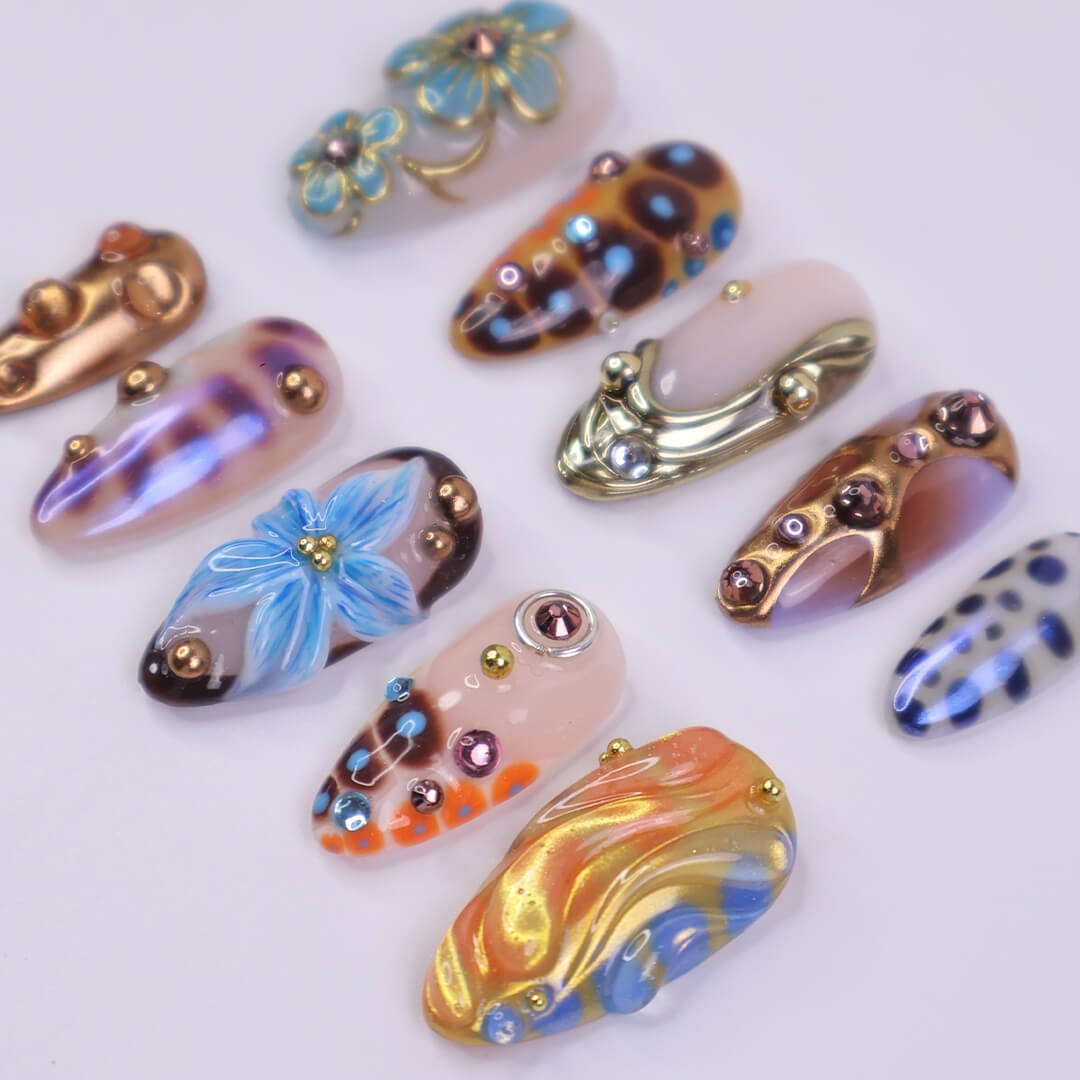 Metallic blue press on nails with sculpted floral accents and bronze chrome — custom almond shape for summer or Y2K looks

