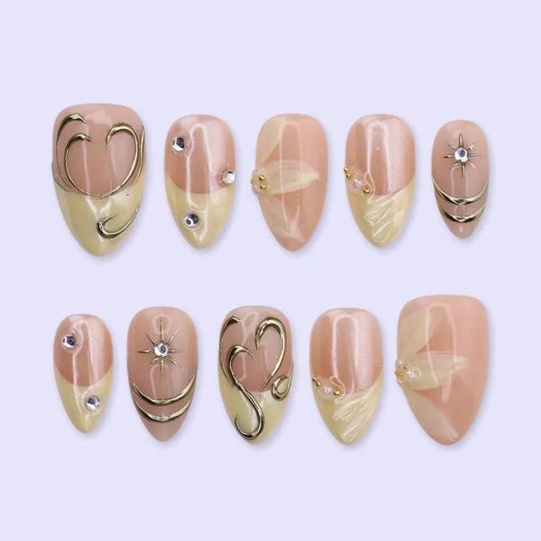 3D gold chrome French tip press on nails with swirl accents, embellished with starburst crystals and white floral details on a nude base — custom press on nails, luxury handmade nail art, fake nails, false nails, pressons — perfect for prom, weddings, and spring events