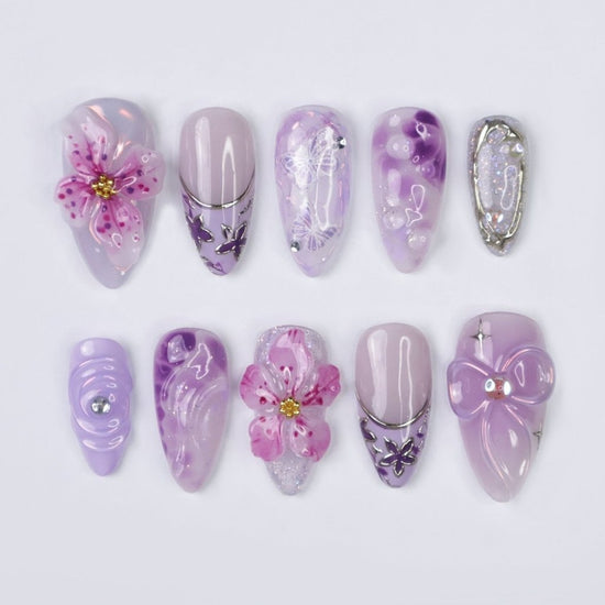 3D purple and lavender press on nails with butterfly art, pink sakura flowers, glossy swirls, and crystal bow charms — custom press on nails, luxury handmade nail art, fake nails, false nails, pressons — perfect for spring, summer, romantic gifts, or soft aesthetic lovers