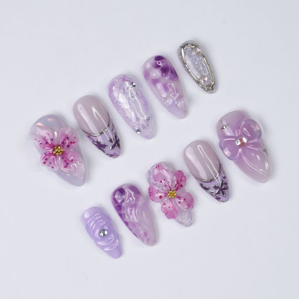 3D purple and lavender press on nails with butterfly art, pink sakura flowers, glossy swirls, and crystal bow charms — custom press on nails, luxury handmade nail art, fake nails, false nails, pressons — perfect for spring, summer, romantic gifts, or soft aesthetic lovers