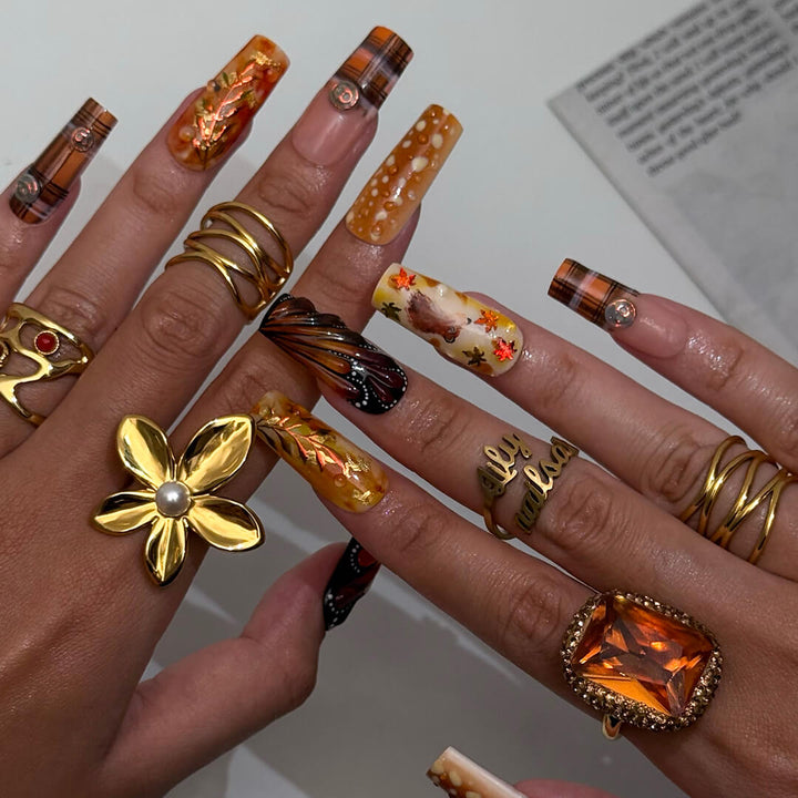 Luxury press-on nails with plaid patterns, golden foil leaves, tortoiseshell swirls, and warm caramel tones — handmade long almond nails — perfect for fall-inspired nail art, luxury everyday style, or elegant seasonal looks.