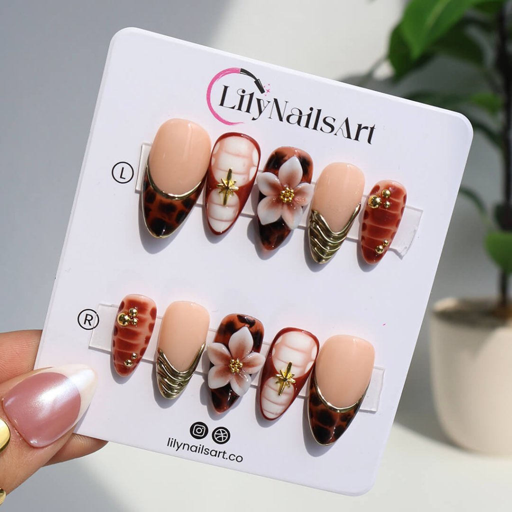 Luxury press-on nails with tortoiseshell patterns, 3D florals, and gold metallic accents on warm amber and nude bases — handmade medium almond nails — perfect for elegant everyday wear, chic autumn looks, or timeless luxury nail art.