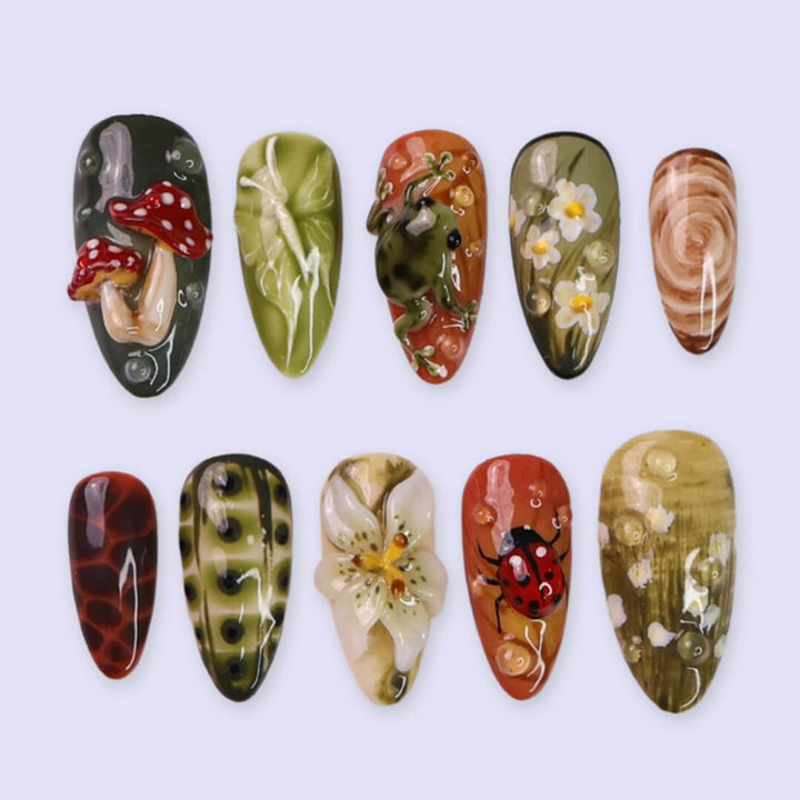 3D enchanted forest press-on nails with sculpted mushrooms, frogs, ladybugs, flowers, and woodland textures in earthy greens, browns, and reds — handmade medium almond nails — perfect for fairytale nail art, mystical styles, or fall luxury looks.