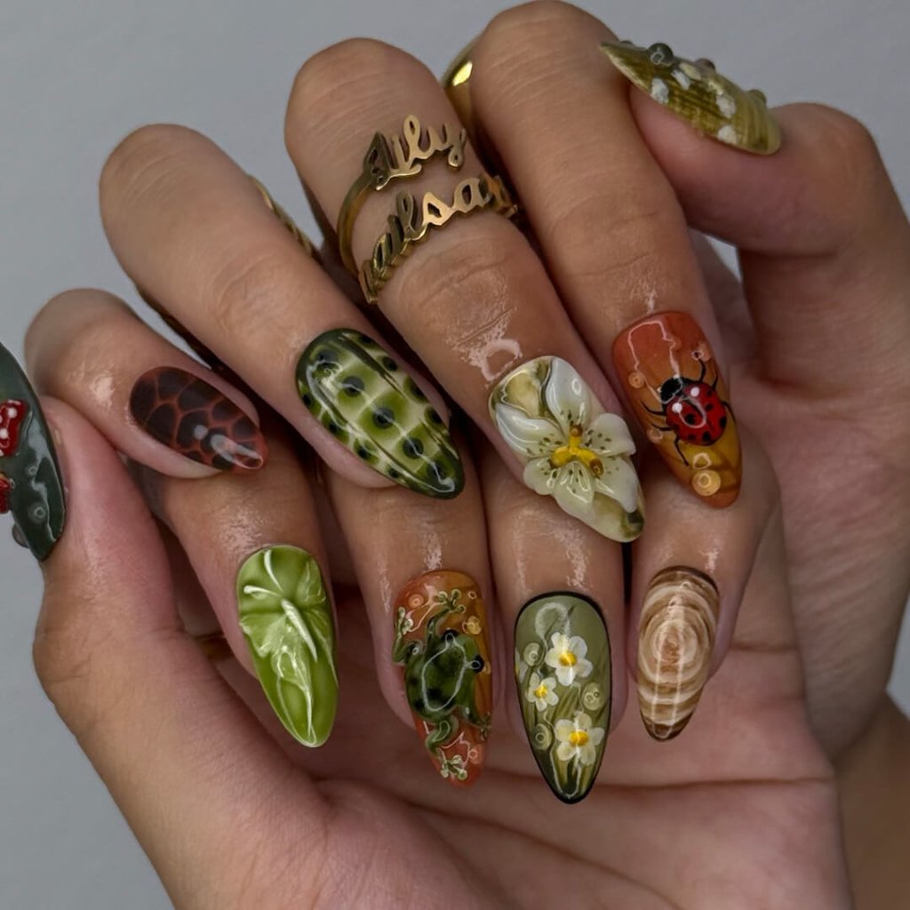 3D enchanted forest press-on nails with sculpted mushrooms, frogs, ladybugs, flowers, and woodland textures in earthy greens, browns, and reds — handmade medium almond nails — perfect for fairytale nail art, mystical styles, or fall luxury looks.