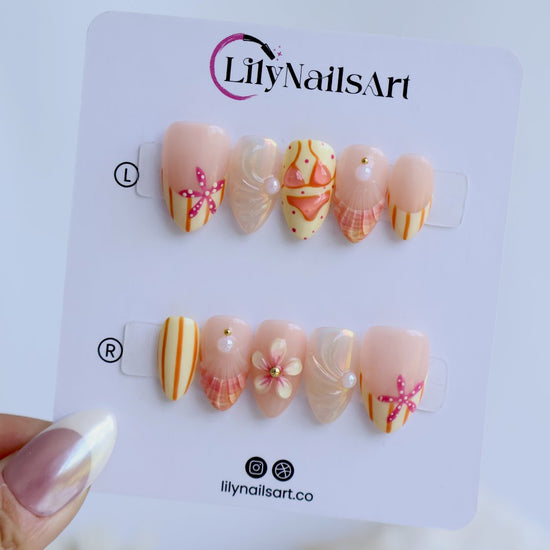 Handmade summer press-on nails with peach base, orange stripes, hand-painted bikini, pink starfish and iridescent seashell shimmer by Lily Nails Art