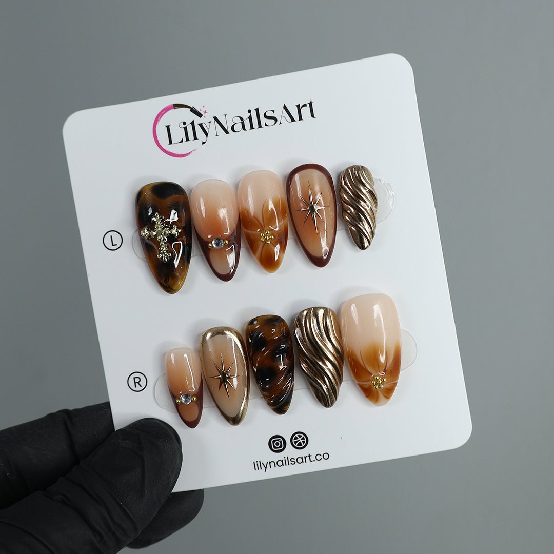 brown presson nails earthy press on nails gold press on nails Rich, sultry, and effortlessly chic. Tortoise shell, gold accents, and silky caramel hues come together for the ultimate luxury nail set. The perfect mix of soft glam and bold elegance, these nails add an expensive touch to every outfit. Whether you're sipping coffee in a sleek blazer or dressing up for a night out, this set is your new obsession. 
