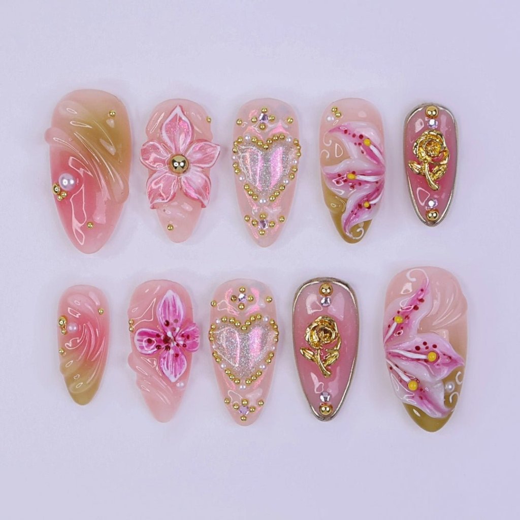 3D pink press on nails with floral and heart designs, embellished with gold studs, glitter accents, and hand-shaped lily flowers — custom press on nails, luxury handmade nail art, fake nails, false nails, pressons — perfect for spring, weddings, holidays, birthdays, or a thoughtful gift for her.