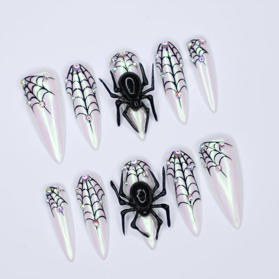 White chrome stiletto Halloween press on nails with 3D black spiders, spiderweb line art, and iridescent crystal accents — handmade spooky press-ons, custom fake nails for Halloween parties, creepy cute nail art, horror fashion aesthetic.