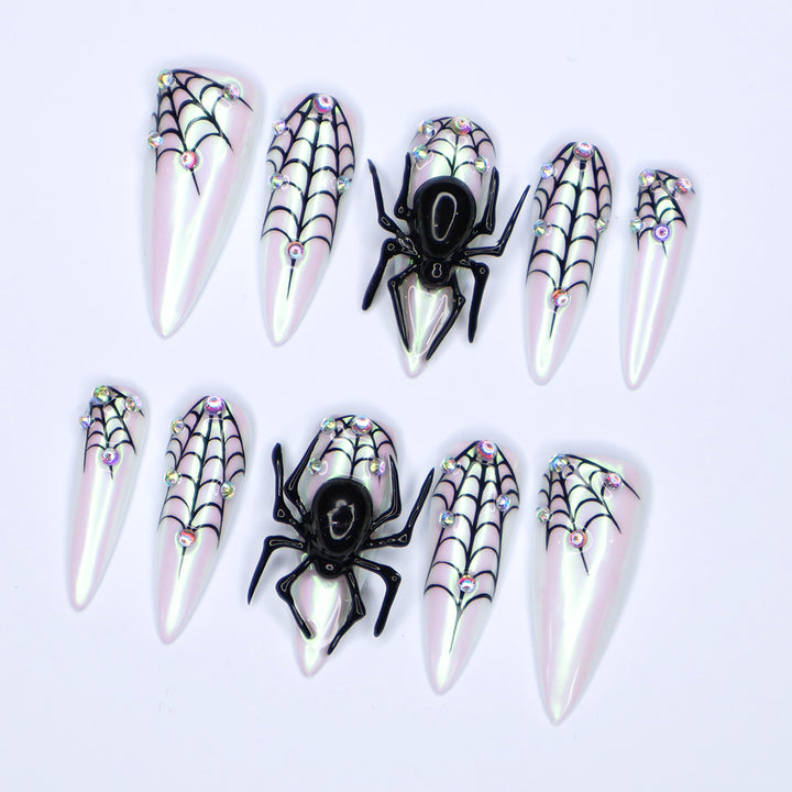 White chrome stiletto Halloween press on nails with 3D black spiders, spiderweb line art, and iridescent crystal accents — handmade spooky press-ons, custom fake nails for Halloween parties, creepy cute nail art, horror fashion aesthetic.