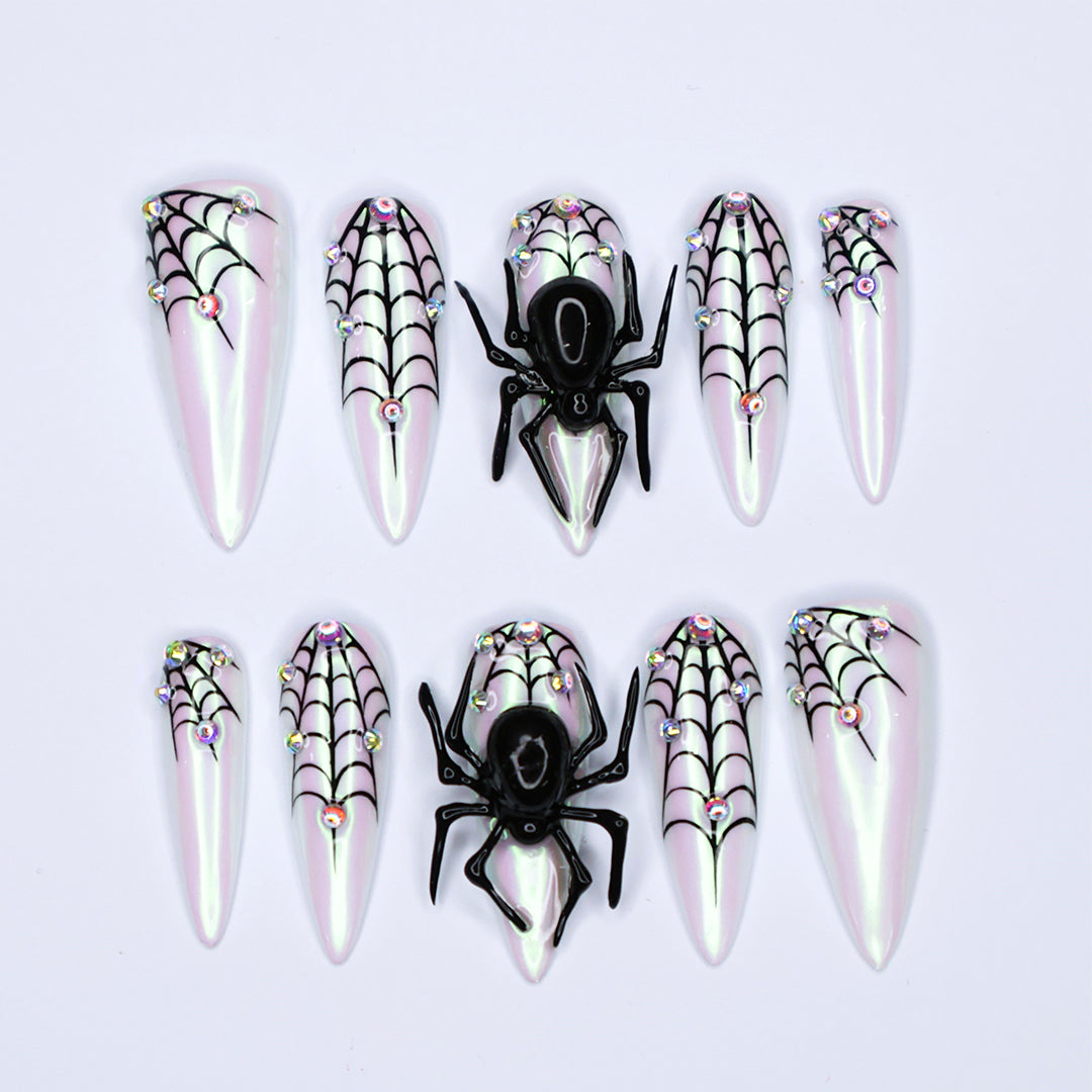 White chrome stiletto Halloween press on nails with 3D black spiders, spiderweb line art, and iridescent crystal accents — handmade spooky press-ons, custom fake nails for Halloween parties, creepy cute nail art, horror fashion aesthetic.