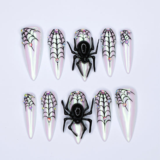White chrome stiletto Halloween press on nails with 3D black spiders, spiderweb line art, and iridescent crystal accents — handmade spooky press-ons, custom fake nails for Halloween parties, creepy cute nail art, horror fashion aesthetic.