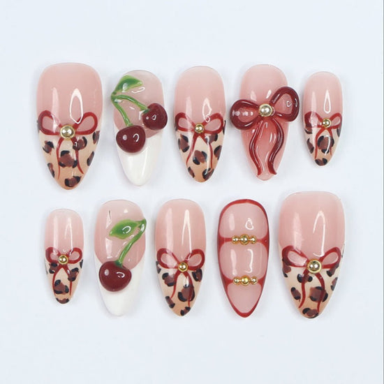 Chic designer press-on nails featuring a bold mix of leopard print, 3D cherries, and sculpted bows. These salon-quality, reusable press-on nails blend trendy animal print with playful, glossy red accents for a stylish and feminine look. A premium alternative to Kiss and Glamour Press-On Nails, perfect for fashion-forward nail lovers. Shop custom, high-quality press-on nails for a long-lasting, statement manicure.
