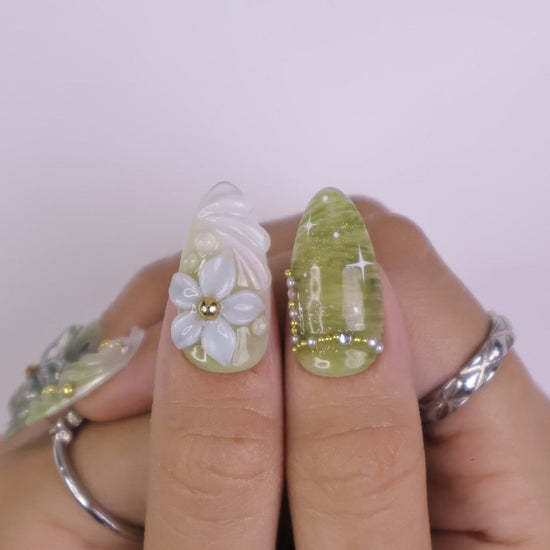 Awaken the spirit of the forest with Sylvara, a graceful press-on nail set woven with misty greens, sparkling silver details, and sculpted 3D florals. Blending soft gradients, leafy textures, and dewdrop-like accents, Sylvara captures the quiet magic of nature’s hidden groves. 🌿