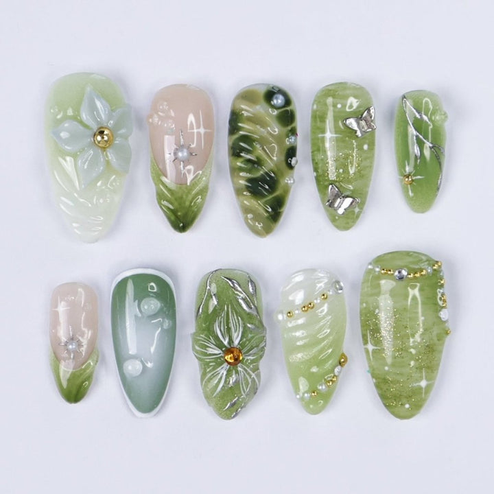 Awaken the spirit of the forest with Sylvara, a graceful press-on nail set woven with misty greens, sparkling silver details, and sculpted 3D florals. Blending soft gradients, leafy textures, and dewdrop-like accents, Sylvara captures the quiet magic of nature’s hidden groves. 🌿
