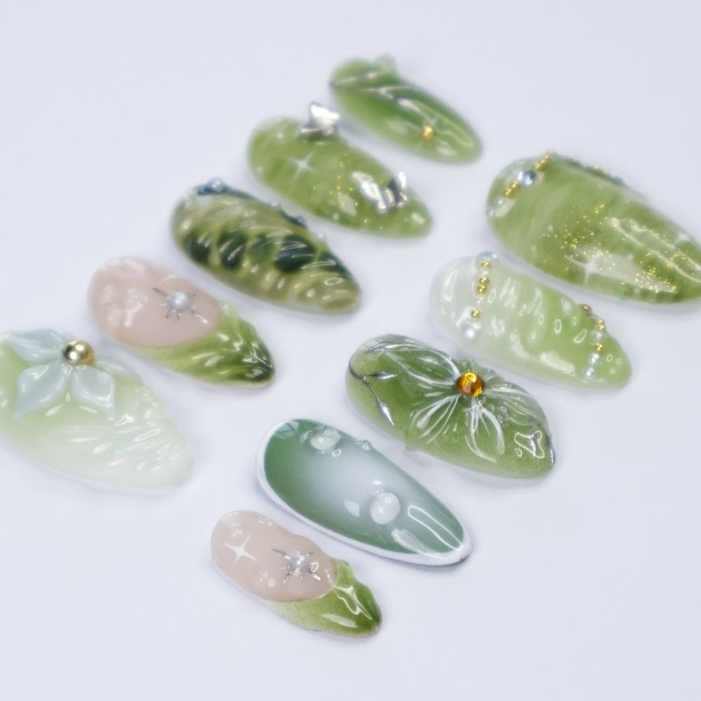Awaken the spirit of the forest with Sylvara, a graceful press-on nail set woven with misty greens, sparkling silver details, and sculpted 3D florals. Blending soft gradients, leafy textures, and dewdrop-like accents, Sylvara captures the quiet magic of nature’s hidden groves. 🌿