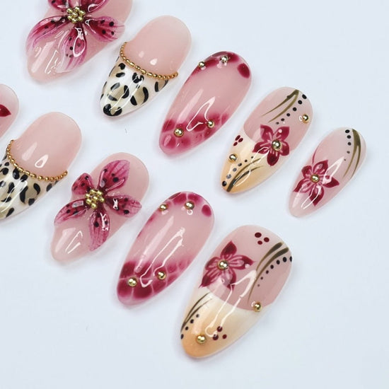 Handmade spring press-on nails featuring delicate 3D sakura flowers, leopard print French tips, and gold accents. Designed in a soft pink color palette with a glossy finish, perfect for floral nail lovers, holiday nails, vacation-ready nails, and birthday nail sets.